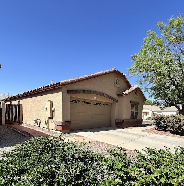 1827 E Carla Vista Dr, Gilbert, AZ 85295 - view of side of property featuring stucco siding, an attached garage, driveway, and a tile roof