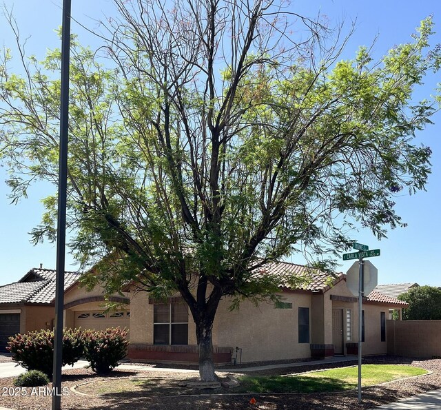1827 E Carla Vista Dr, Gilbert, AZ 85295 - view of home's exterior with a tile roof, a garage, stucco siding, and fence