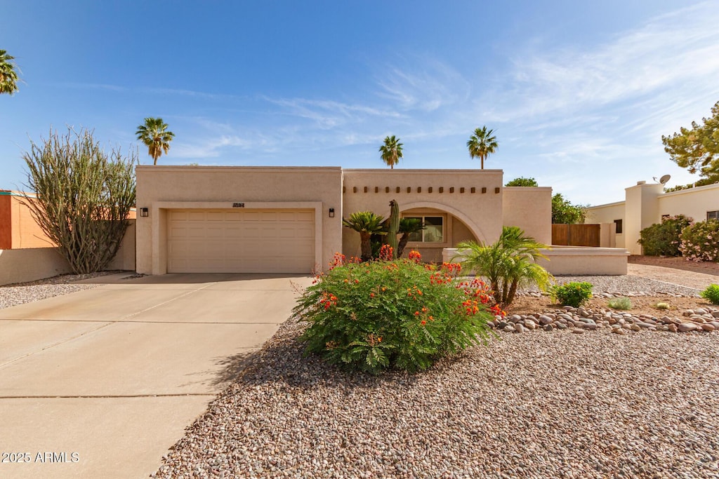 4527 E Sunrise Dr, Phoenix, AZ 85044 - pueblo-style house with concrete driveway, stucco siding, and a garage