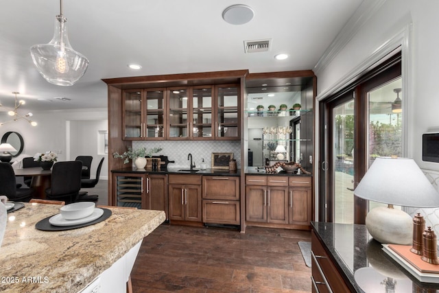 bar with decorative backsplash, dark hardwood / wood-style flooring, beverage cooler, pendant lighting, and dark stone countertops