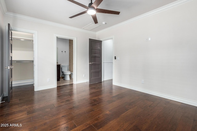 unfurnished bedroom with ornamental molding, ceiling fan, dark wood-type flooring, a spacious closet, and connected bathroom