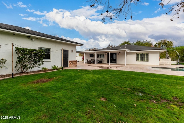 back of house featuring a lawn, a patio, and a swimming pool