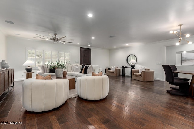 living room with ornamental molding, ceiling fan with notable chandelier, and dark wood-type flooring