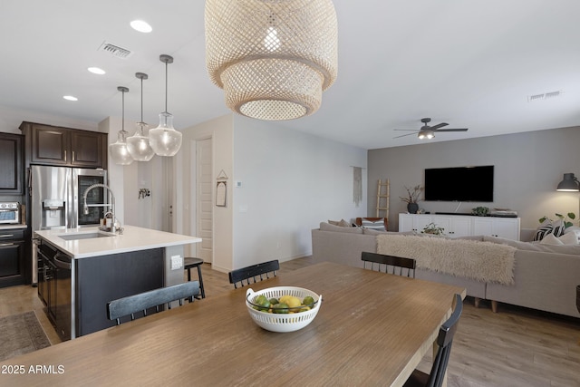 dining space featuring recessed lighting, visible vents, ceiling fan with notable chandelier, and light wood-type flooring