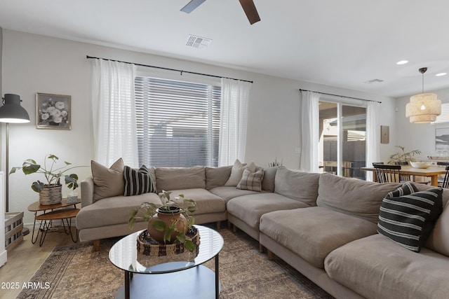 living room with wood finished floors, visible vents, and a healthy amount of sunlight