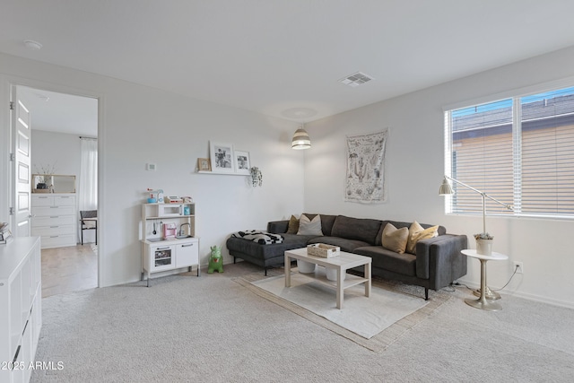 carpeted living room featuring baseboards and visible vents