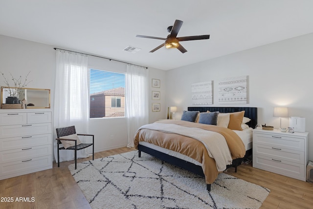 bedroom with light wood finished floors, visible vents, and ceiling fan