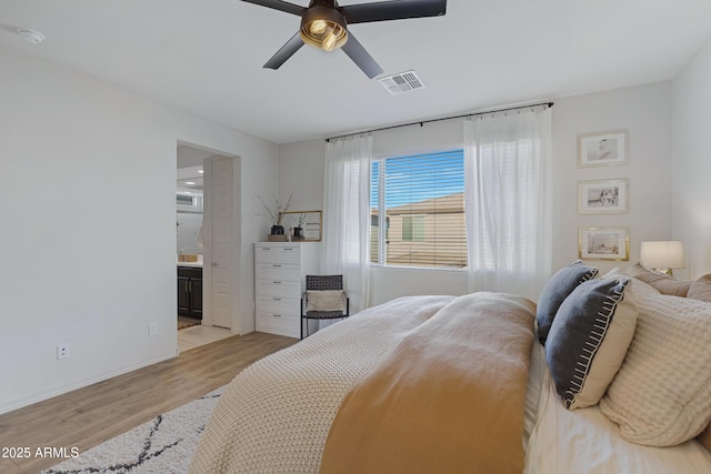 bedroom featuring visible vents, connected bathroom, light wood finished floors, baseboards, and ceiling fan