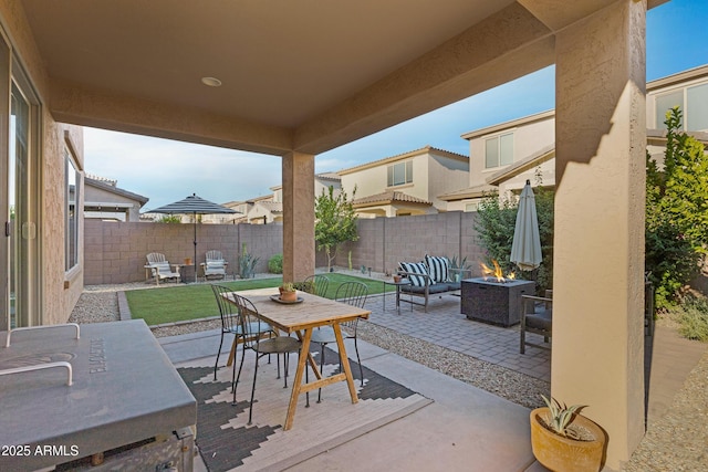 view of patio / terrace featuring an outdoor living space with a fire pit, a fenced backyard, and outdoor dining space