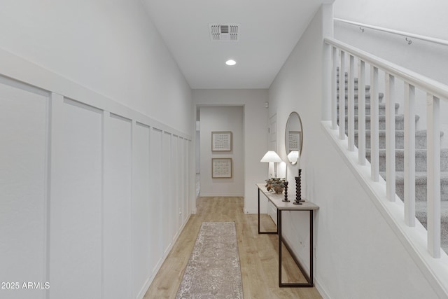 corridor with recessed lighting, visible vents, stairway, and light wood finished floors