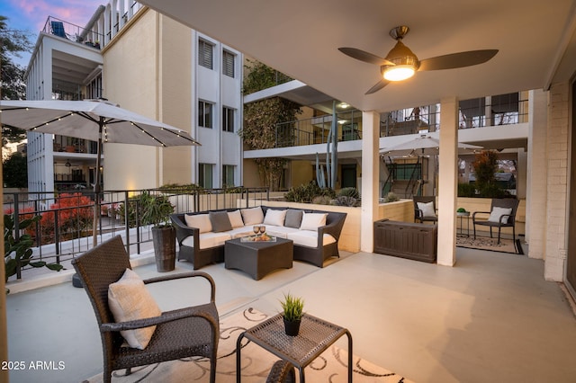 patio terrace at dusk with an outdoor living space with a fire pit and ceiling fan