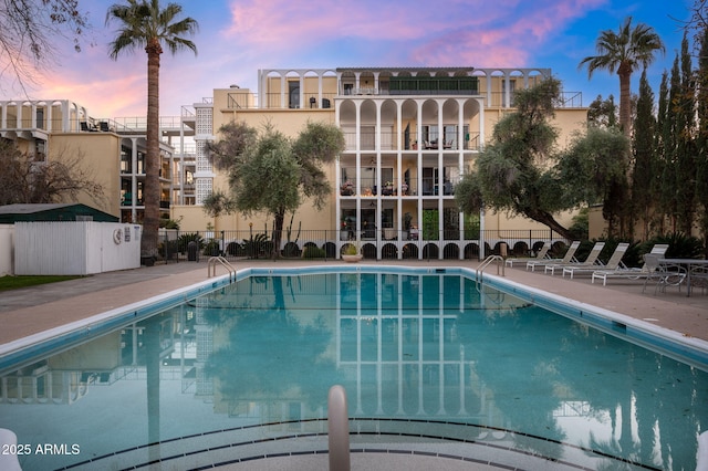 pool at dusk featuring a patio area