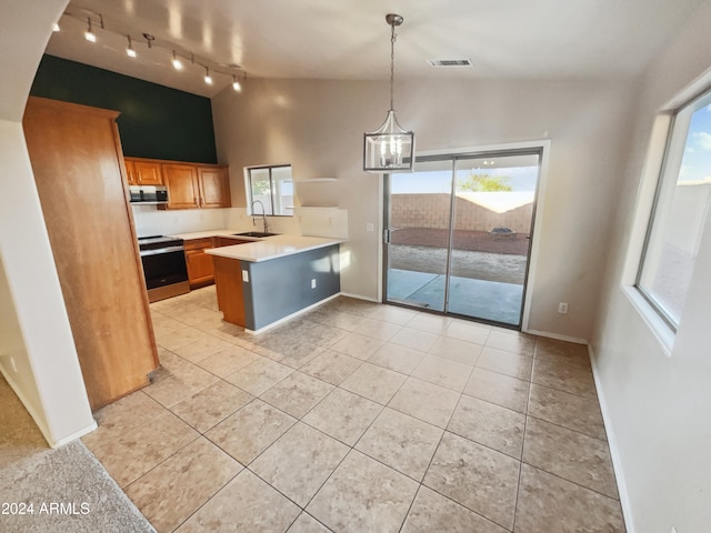 kitchen featuring kitchen peninsula, appliances with stainless steel finishes, sink, pendant lighting, and lofted ceiling