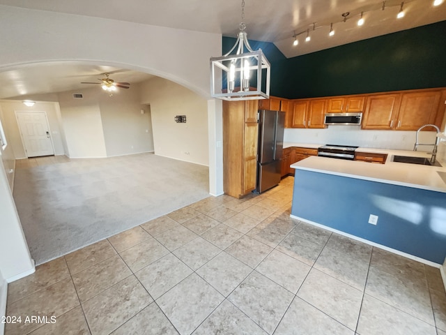 kitchen with lofted ceiling, light carpet, hanging light fixtures, sink, and stainless steel appliances