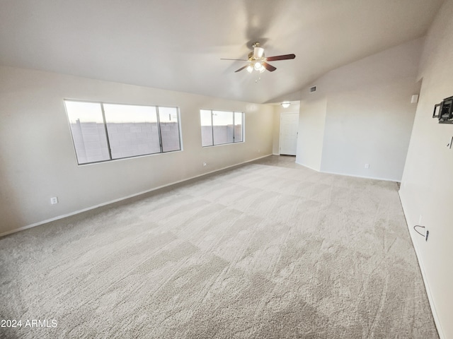 empty room with ceiling fan, light colored carpet, and lofted ceiling