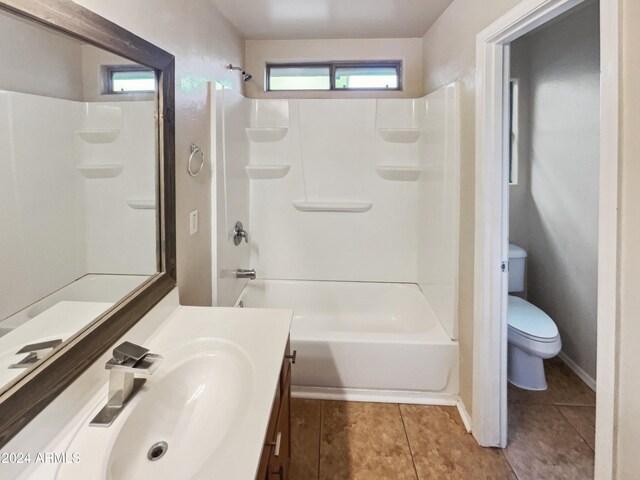 full bathroom with tile patterned floors, washtub / shower combination, vanity, and toilet