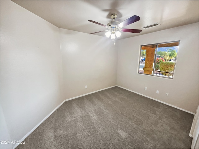 unfurnished room with dark colored carpet and ceiling fan