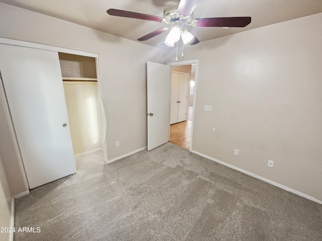 unfurnished bedroom featuring ceiling fan, light carpet, and a closet