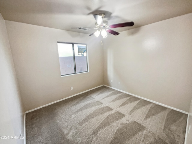 spare room featuring ceiling fan and carpet