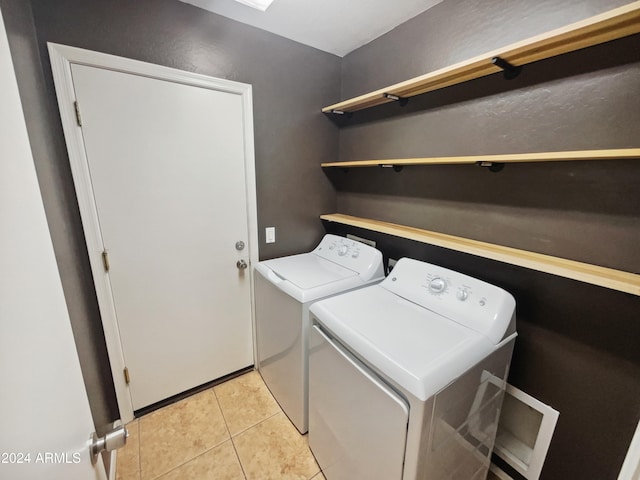 clothes washing area with separate washer and dryer and light tile patterned floors