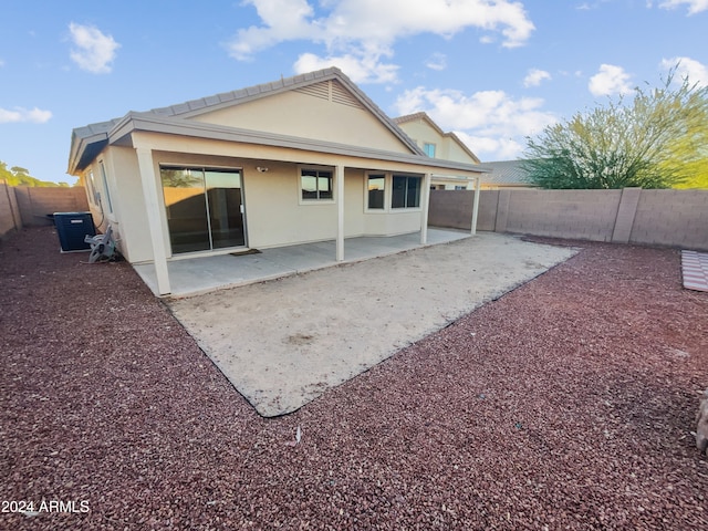 rear view of property with central air condition unit and a patio area