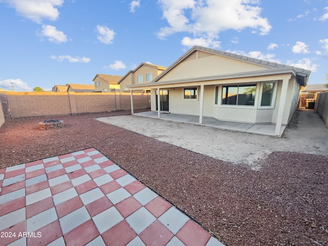 rear view of property with a patio area and a fire pit