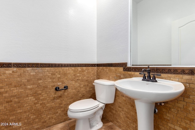 bathroom featuring tile walls, toilet, tile patterned floors, and tasteful backsplash