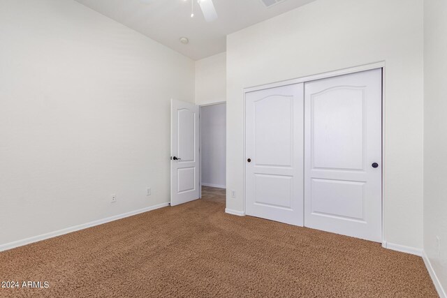 unfurnished bedroom with carpet flooring, ceiling fan, and a closet