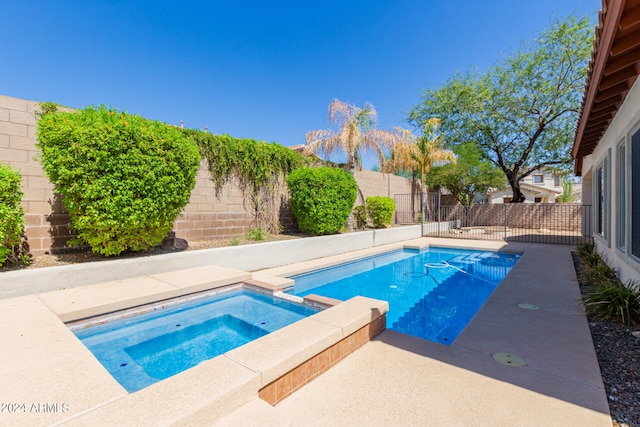 view of swimming pool with an in ground hot tub