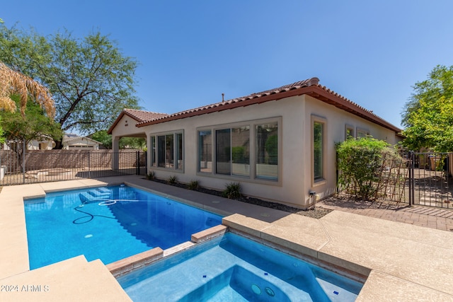 view of swimming pool featuring an in ground hot tub and a patio area