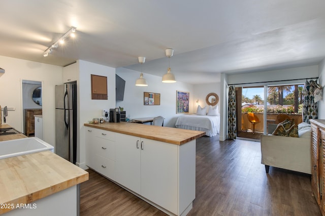 4727 E Lafayette Blvd Unit 211, Phoenix, AZ 85018 - kitchen with wooden counters, freestanding refrigerator, open floor plan, white cabinetry, and a peninsula