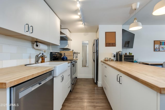 4727 E Lafayette Blvd Unit 211, Phoenix, AZ 85018 - kitchen with wood counters, appliances with stainless steel finishes, wall chimney range hood, decorative backsplash, and white cabinetry