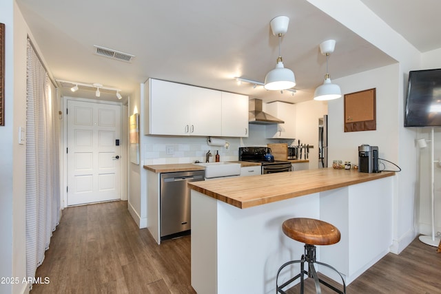4727 E Lafayette Blvd Unit 211, Phoenix, AZ 85018 - kitchen with butcher block countertops, black / electric stove, stainless steel dishwasher, wall chimney exhaust hood, and dark wood-style floors