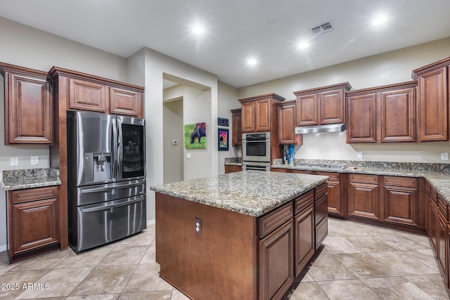 19414 W Pasadena Ave, Litchfield Park, AZ 85340 - kitchen with stainless steel appliances, a kitchen island, light stone counters, recessed lighting, and under cabinet range hood