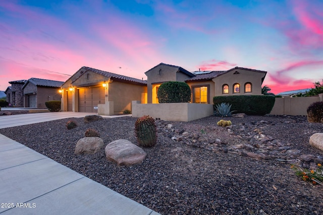 19414 W Pasadena Ave, Litchfield Park, AZ 85340 - mediterranean / spanish-style home featuring stucco siding, an attached garage, fence, concrete driveway, and solar panels