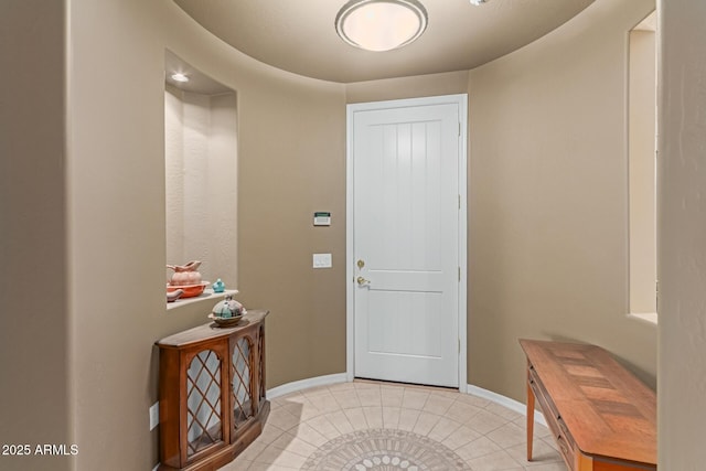 entrance foyer with light tile patterned flooring and baseboards