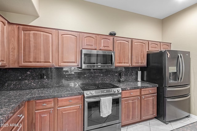 kitchen featuring stainless steel appliances, tile counters, light tile patterned flooring, and decorative backsplash