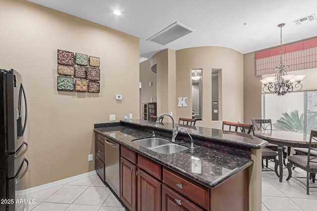 kitchen with visible vents, dark stone counters, stainless steel appliances, pendant lighting, and a sink