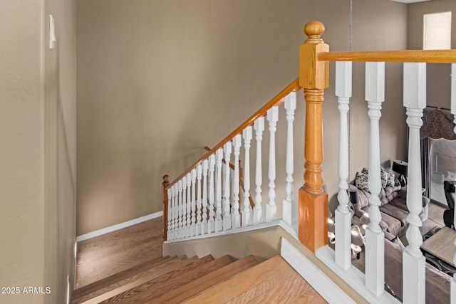 staircase with wood finished floors and baseboards