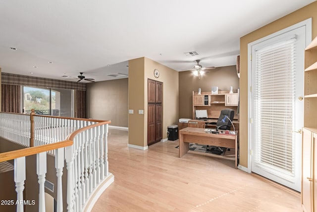 hall featuring an upstairs landing, baseboards, visible vents, and light wood finished floors