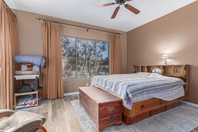 bedroom featuring ceiling fan, light wood-style flooring, and baseboards