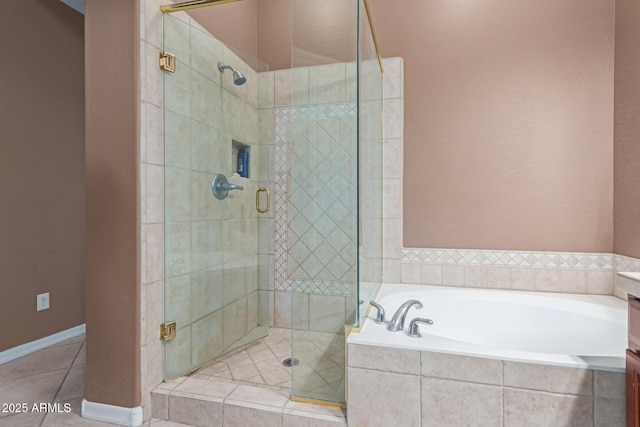 bathroom featuring vanity, baseboards, a shower stall, a bath, and tile patterned floors