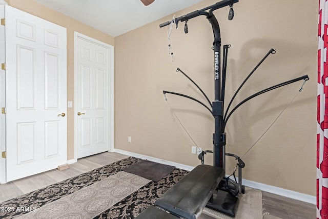 workout area featuring baseboards and wood finished floors