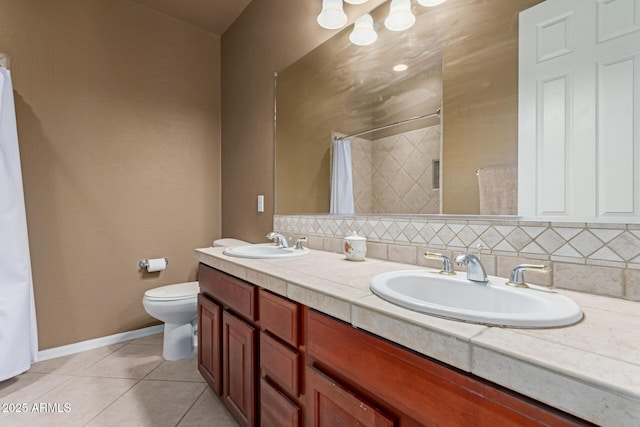 bathroom featuring double vanity, tasteful backsplash, a sink, and tile patterned floors