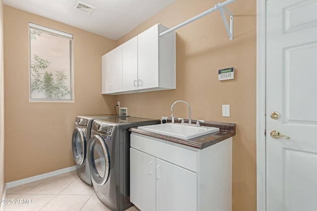 laundry room featuring light tile patterned flooring, separate washer and dryer, a sink, visible vents, and cabinet space