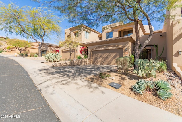 view of front of home featuring a garage, concrete driveway, and stucco siding