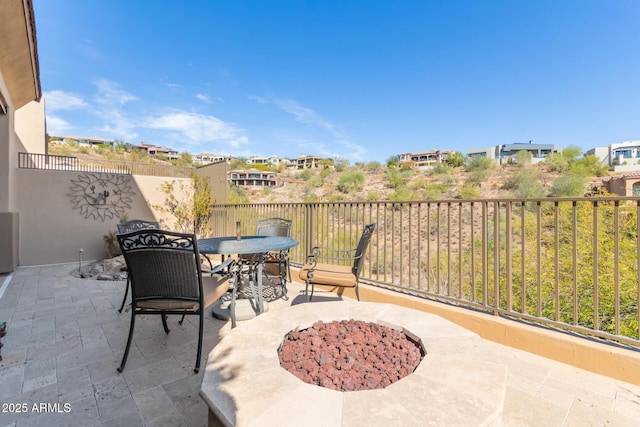 view of patio featuring outdoor dining space, fence, and a fire pit