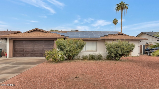 ranch-style house featuring a garage and solar panels