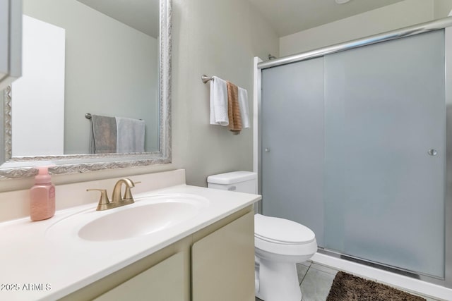 bathroom featuring vanity, an enclosed shower, tile patterned floors, and toilet