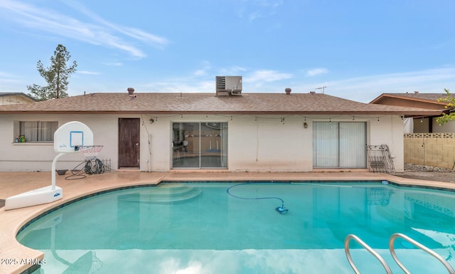 view of pool with central AC unit and a patio